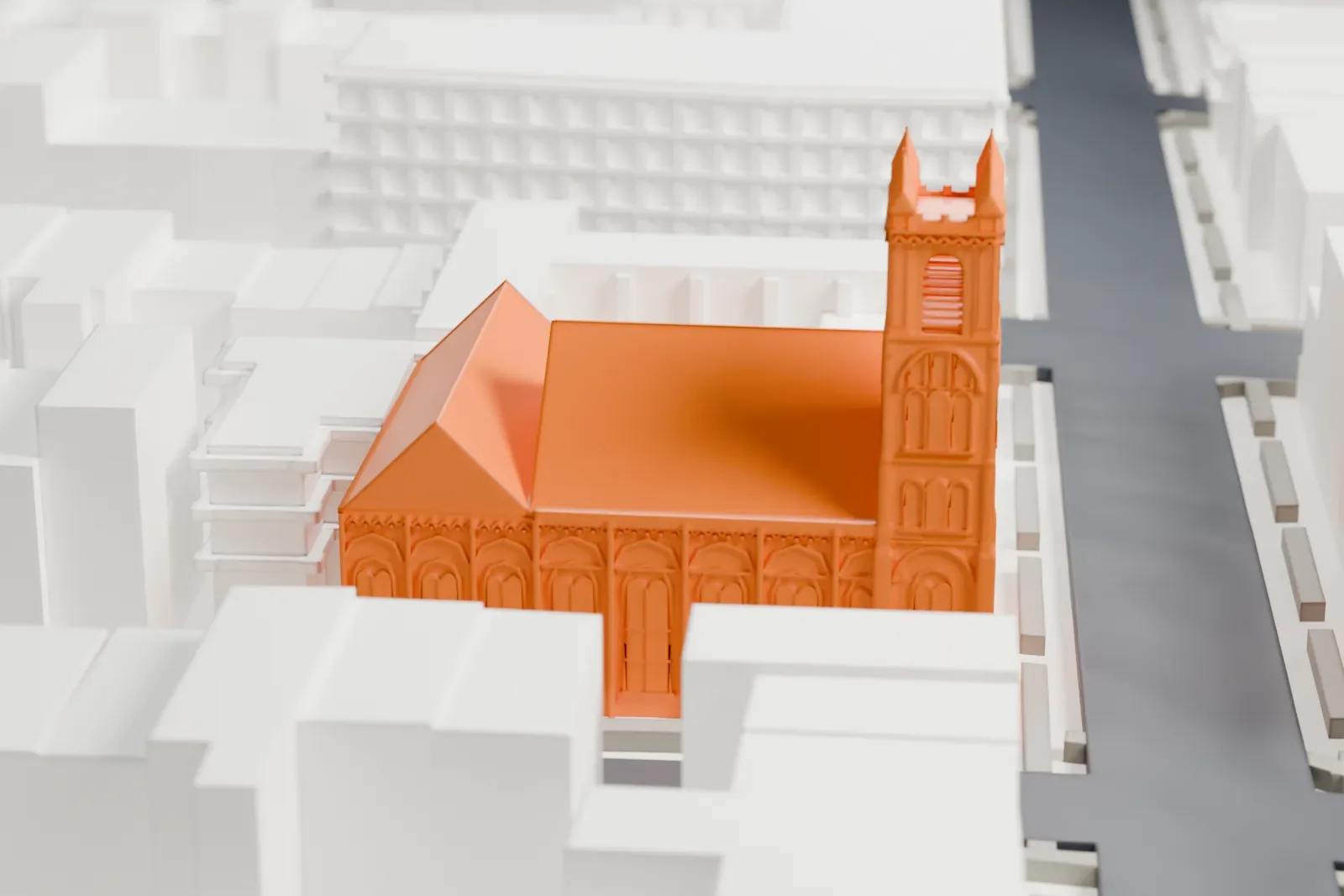 A white 3D print of the South Congregational Church, a gabled church with two pinnacled towers, surrounded by taller buildings, streets and a small green park.