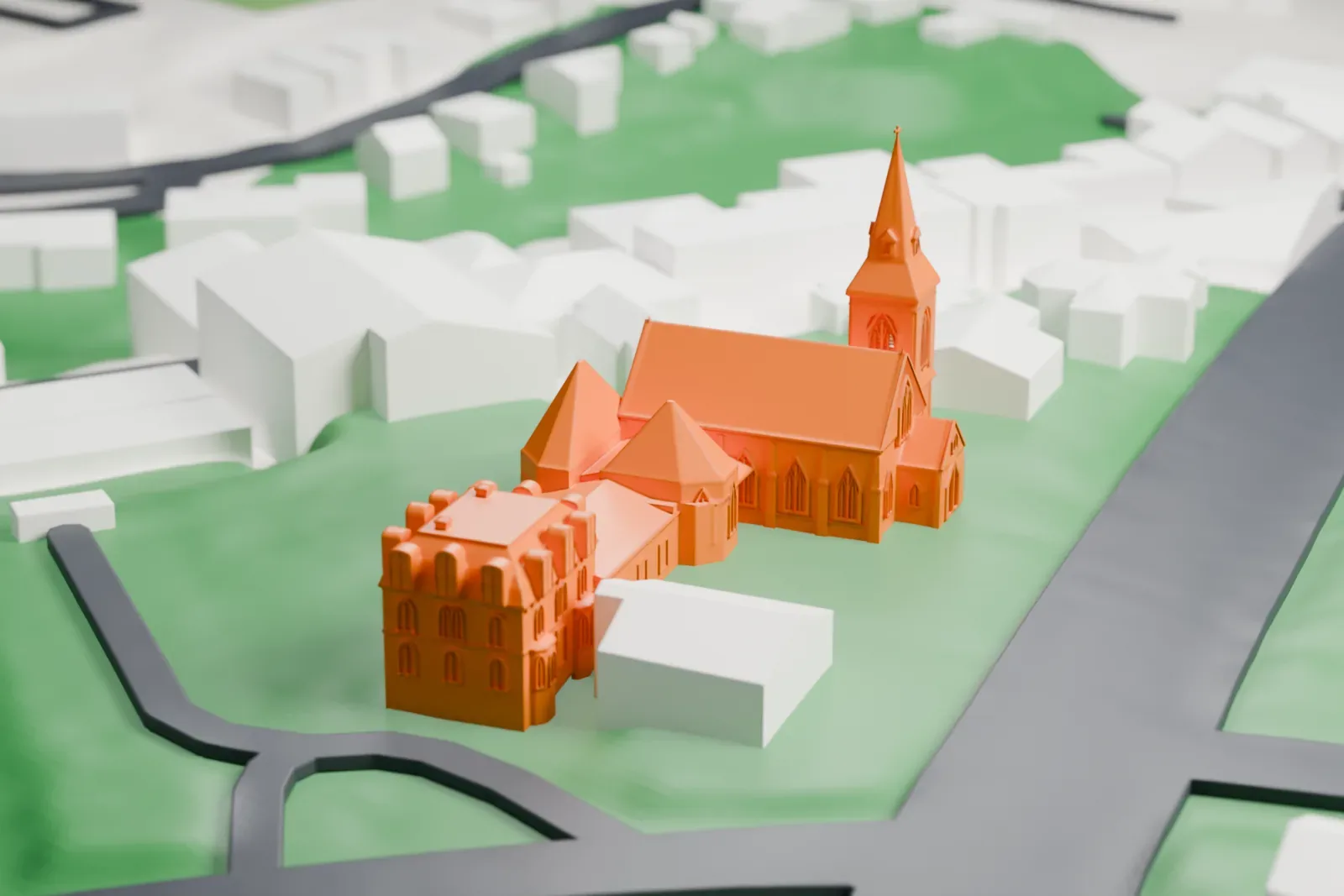 A white 3D print of South Presbyterian Church, a gabled stone church with a tall spired bell tower beside a house with a mansard roof, on green ground with roads.