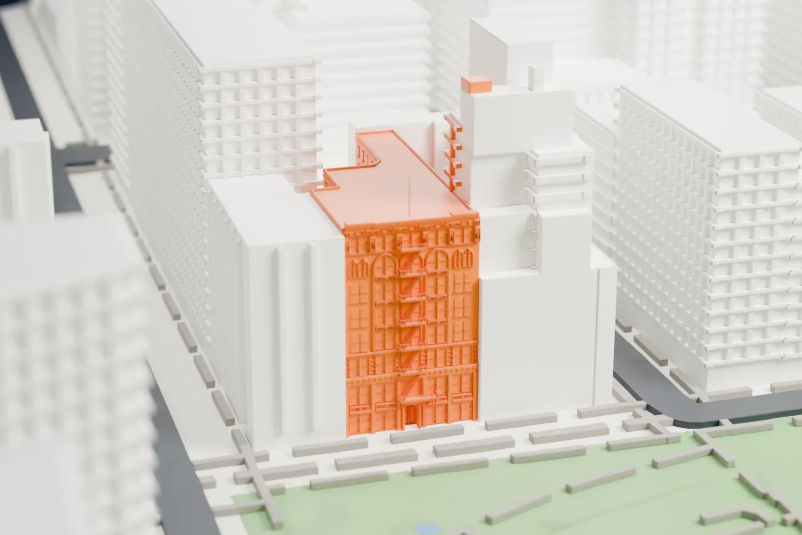 A white 3D print of the Spingler Building, a mid-rise building beside a park, surrounded by taller buildings and streets.