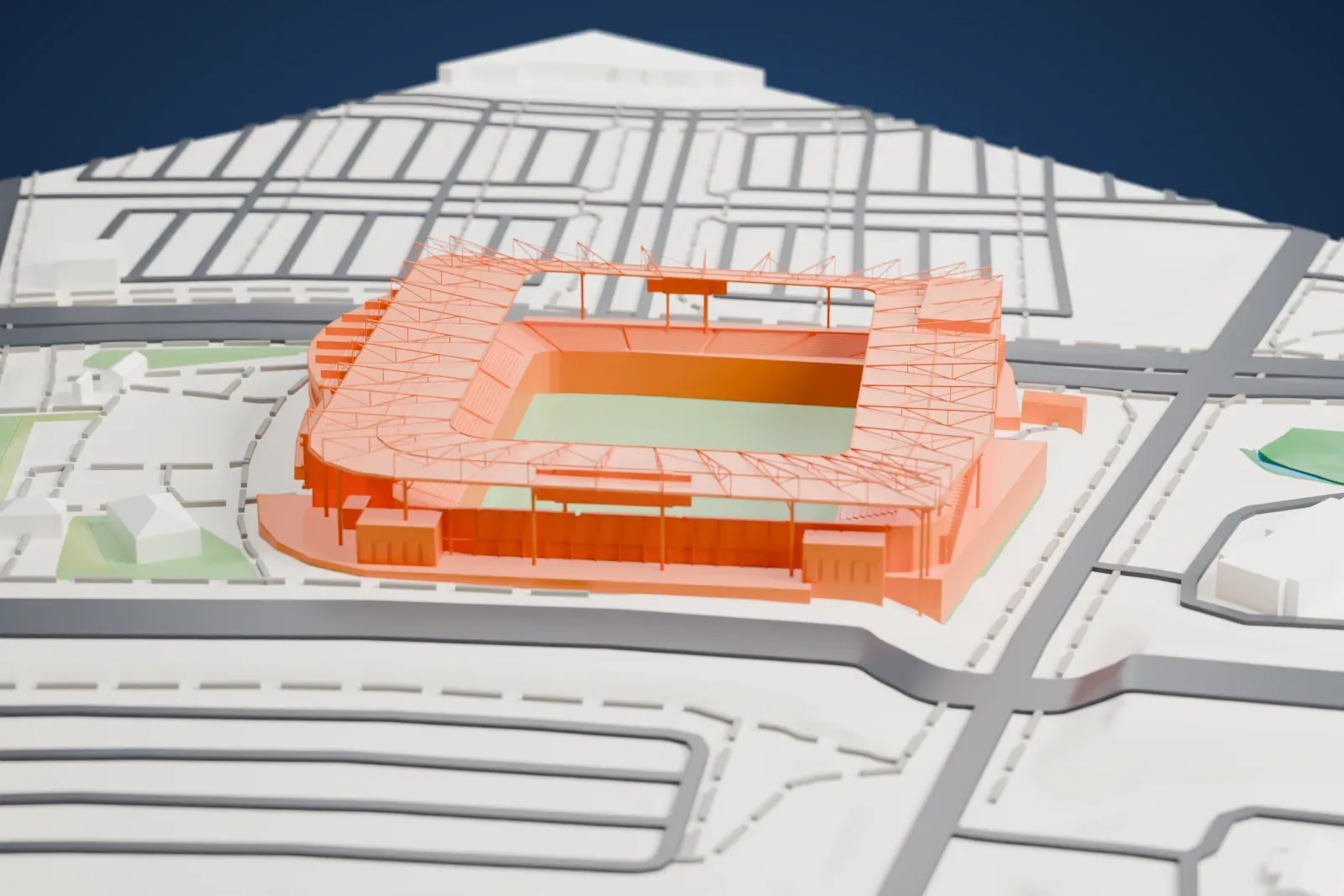 A white 3D print of Sporting Park, an open soccer stadium with a green pitch, tiered stands and a thin roof frame, surrounded by roads, parking areas, small buildings and patches of green.