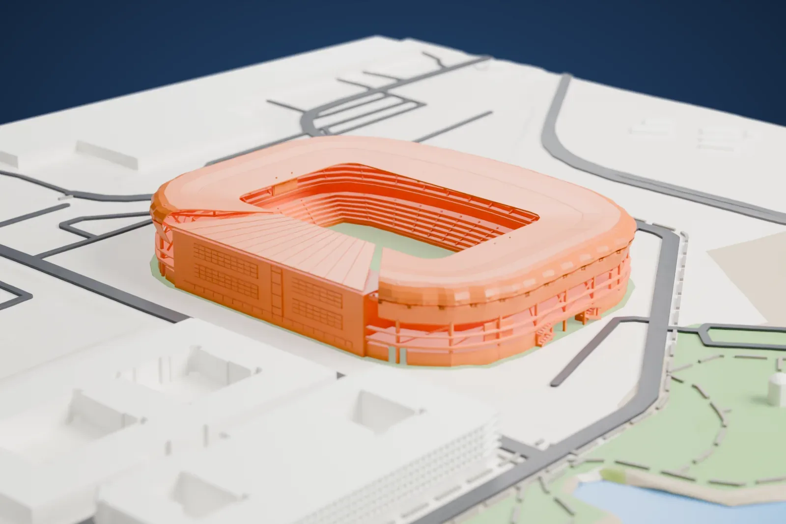 A white 3D print of Sports Illustrated Stadium, an oval stadium with a curved overhanging roof around an open pitch, with a river, a small park, roads and large buildings nearby.