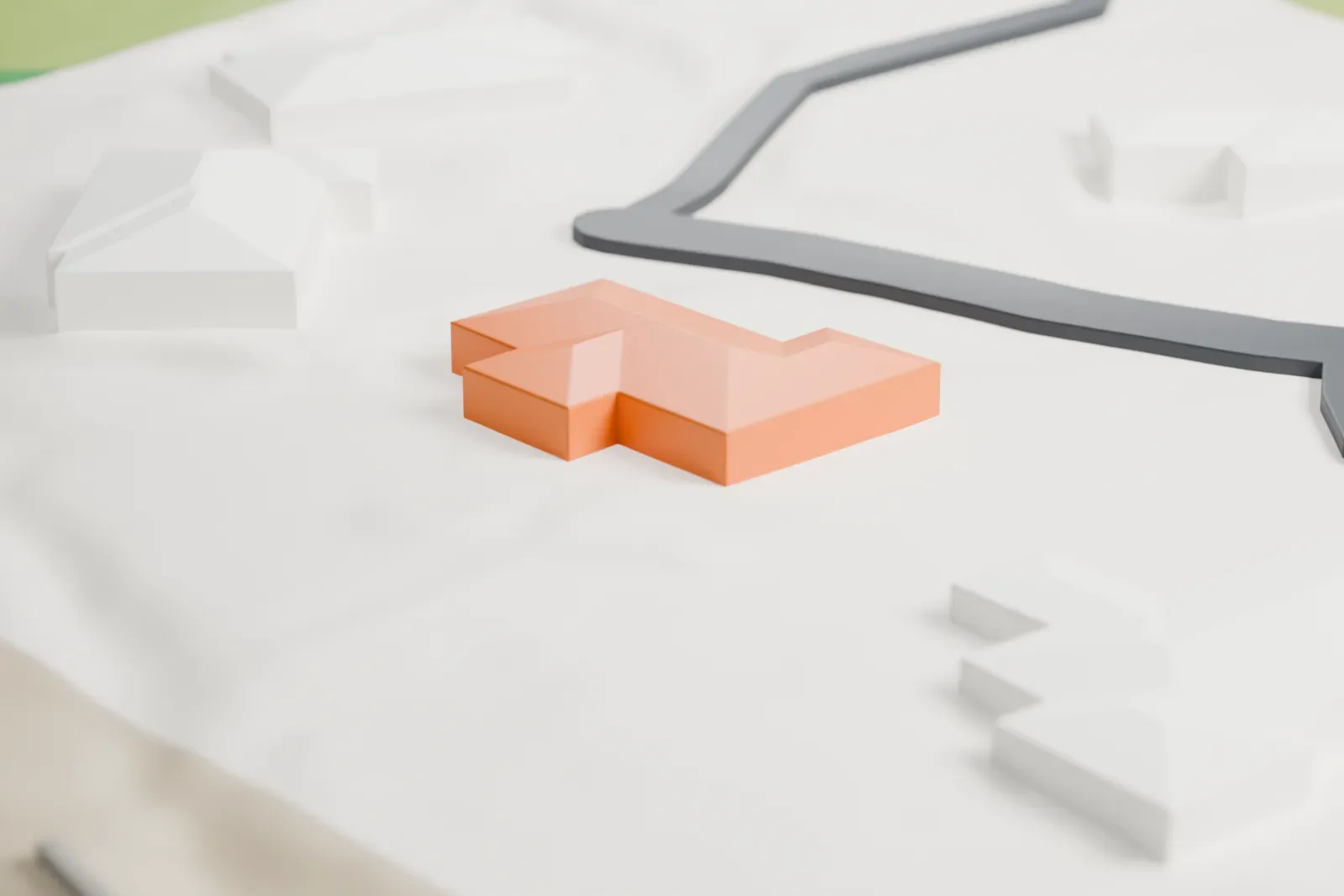 A white 3D print of Squaw Peak Inn, a cluster of low, flat-roofed wings with small windows and doors, beside a curving road.