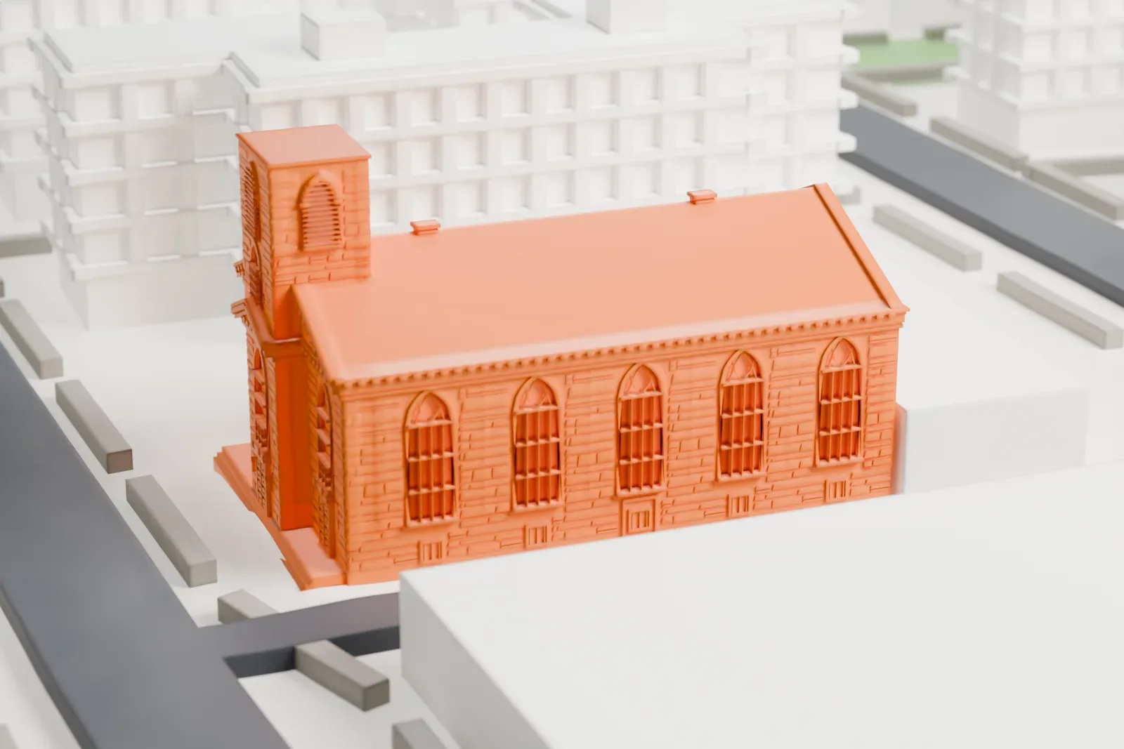 A white 3D print of St. Augustine's Church, a long church with a steep gabled roof and a square tower, among streets and larger buildings.