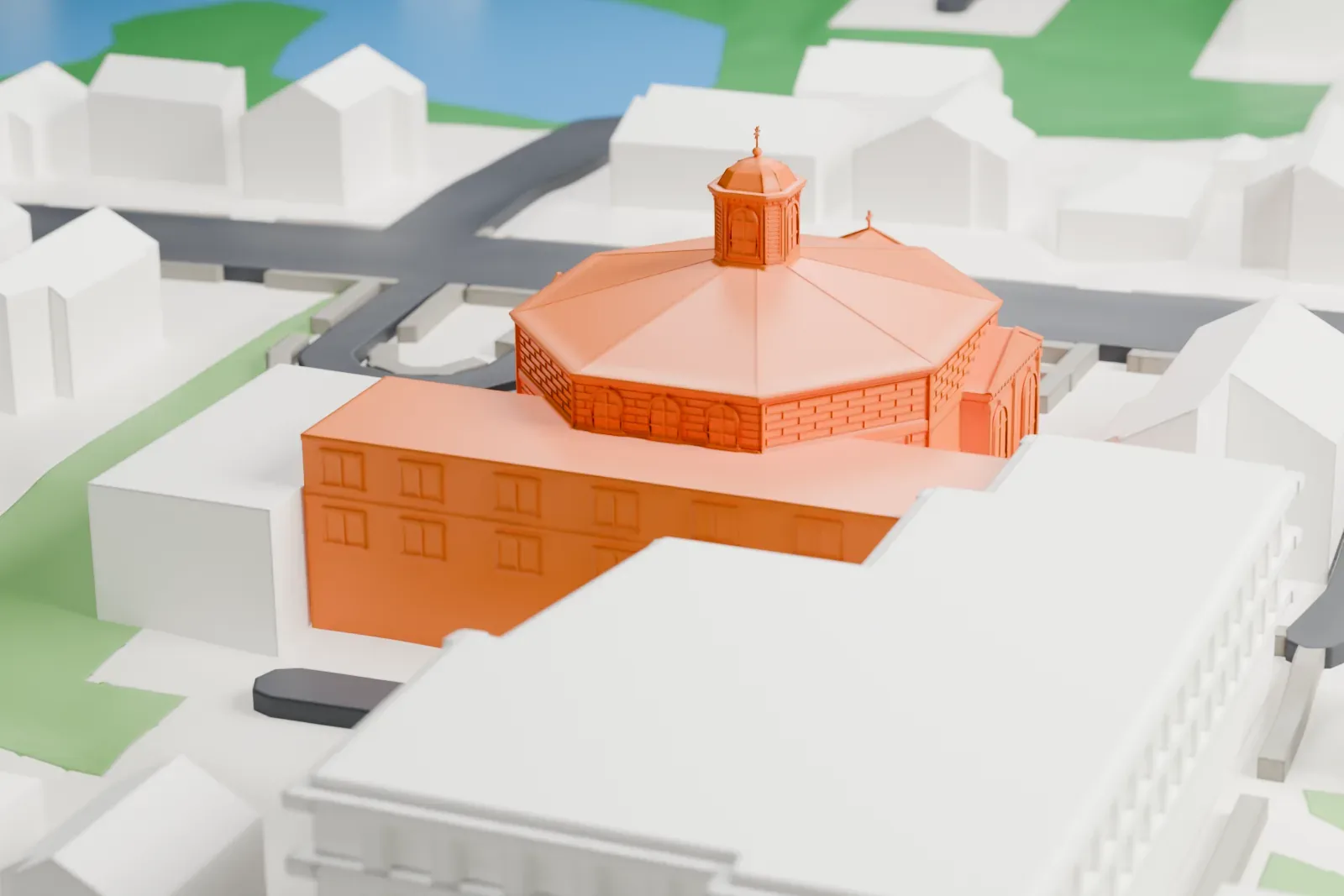 A white 3D print of St. Clare's Church, an octagonal church with a roof lantern and a long side wing, among houses, larger buildings and streets.