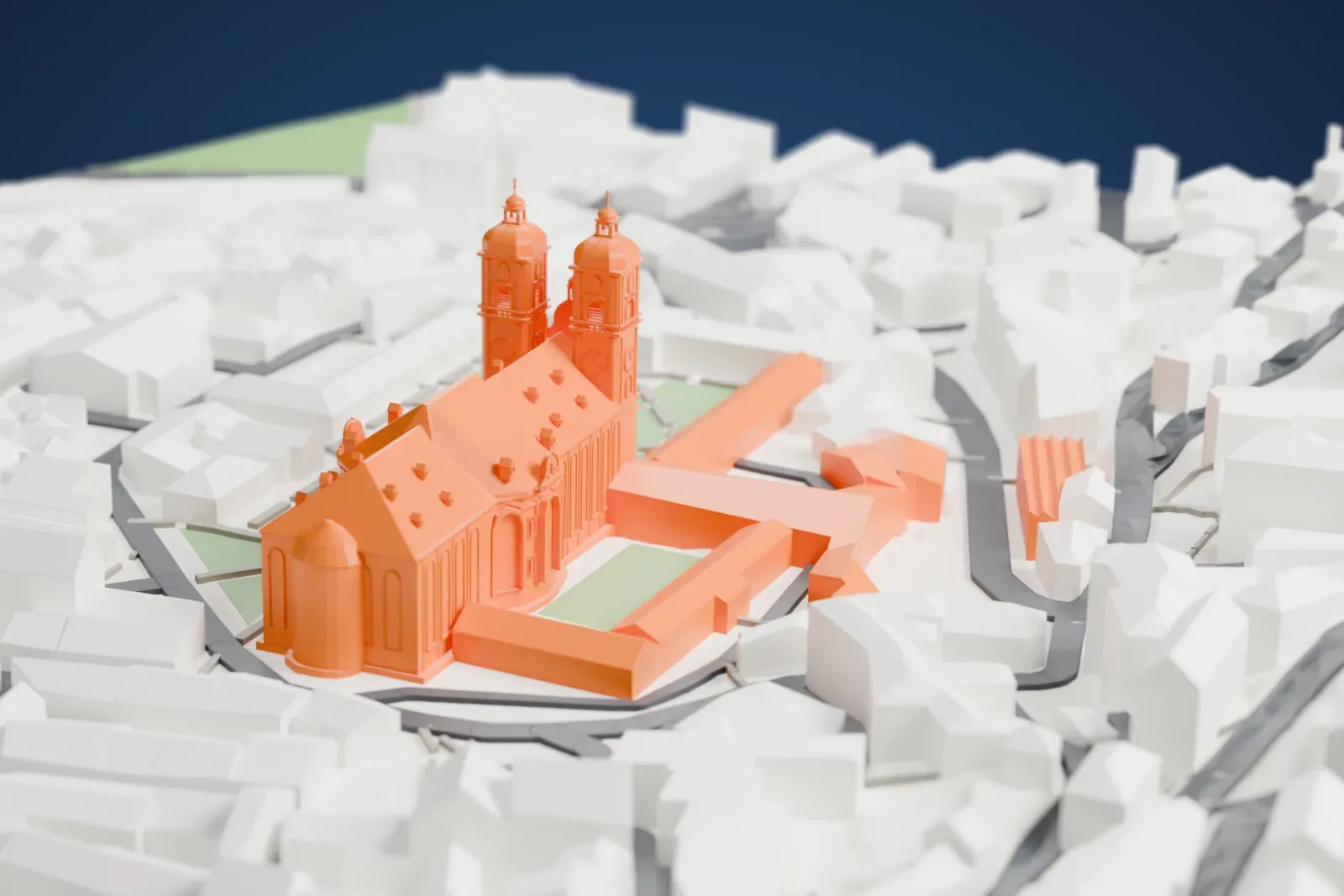 A white 3D print of St. Gallen Cathedral, a long church with two domed towers and a steep roof, among tightly packed buildings and small green squares.