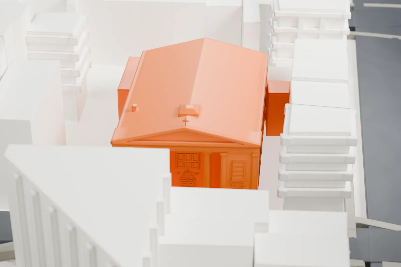 A white 3D print of St. James Roman Catholic Church, a small low building surrounded by tall towers, green lots and streets.