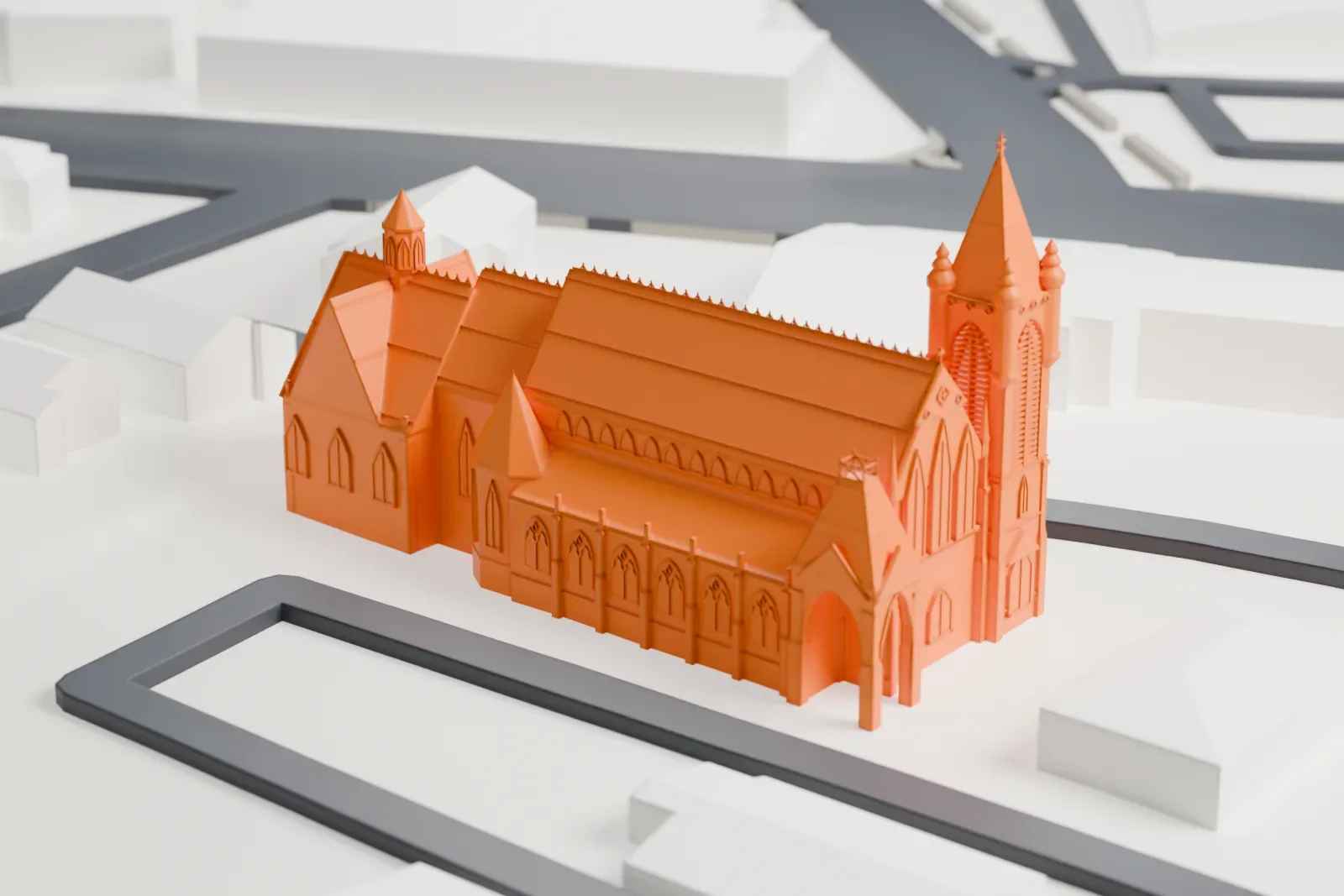 A white 3D print of a long Gothic Revival church with a pointed corner tower, among houses and streets.