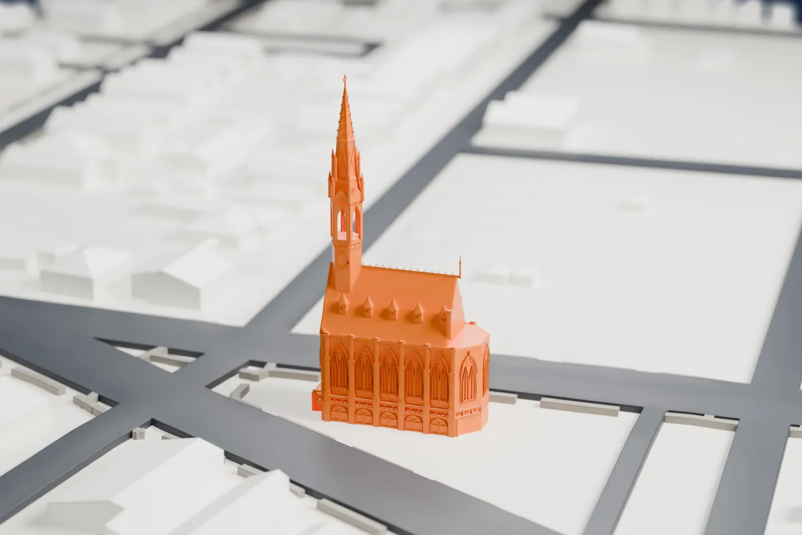 A white 3D print of St. John's Evangelical Lutheran Church, a Gothic-style church with a tall slender spire, on a street corner among low houses.