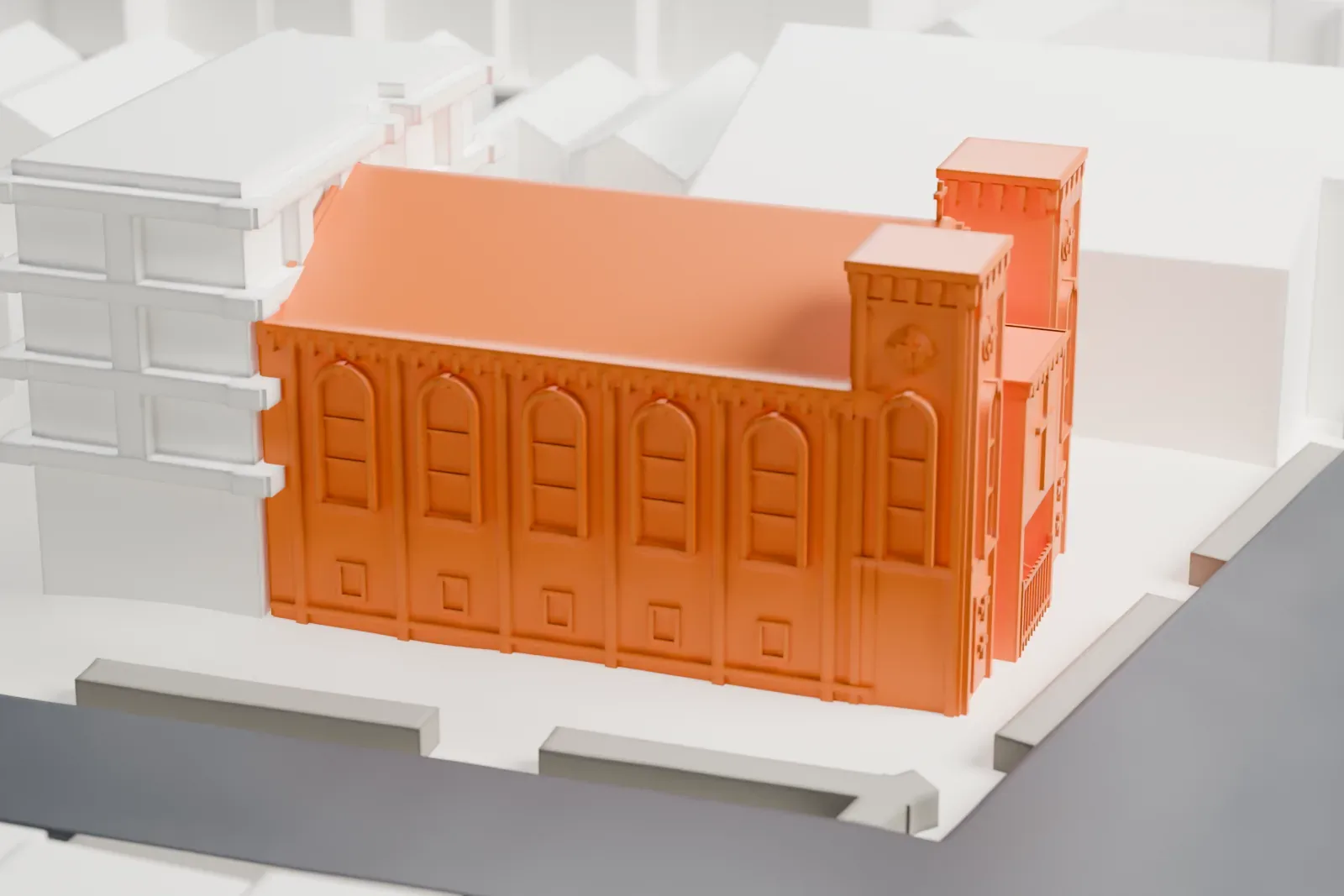 A white 3D print of St. Mark Coptic Orthodox Church, a brick church with two towers and a gabled roof, on a street corner beside a taller building.