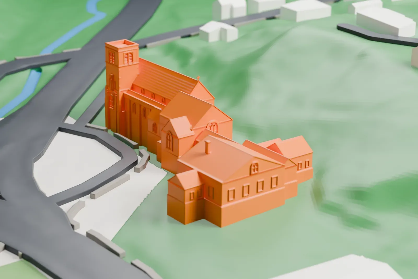 A white 3D print of St. Mark's Episcopal Church, a long church with a square tower and a connected hall, on a green hillside beside roads.