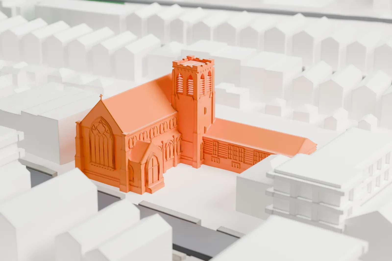 A white 3D print of a church with a long gabled nave and a square tower, among rows of houses and larger buildings.