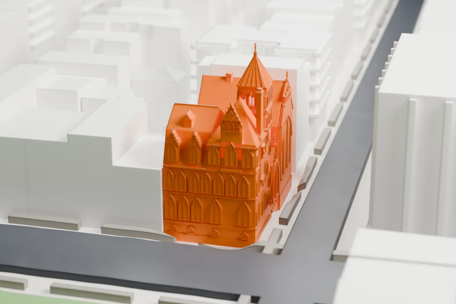 A white 3D print of St. Nicholas of Myra Church, a Gothic-style church with a pointed-arch front and a small tower, on a street corner beside a green park.