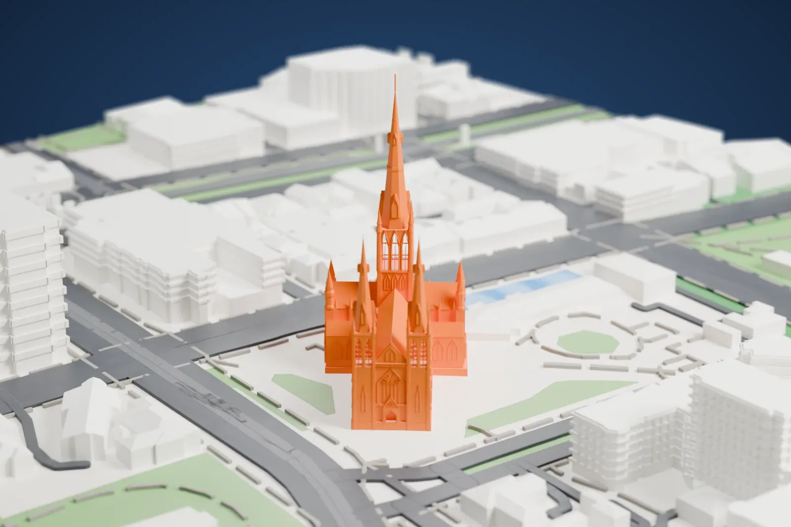 A white 3D print of St Patrick's Cathedral, a Gothic church with a tall central spire topped by a cross, two smaller towers with spires and many pinnacles, standing in a paved block with lawns and streets around it.