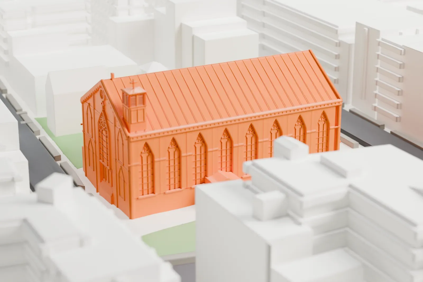 A white 3D print of St. Patrick's Old Cathedral, a long church with a pitched roof and a small bell tower, with lawns and streets around it.