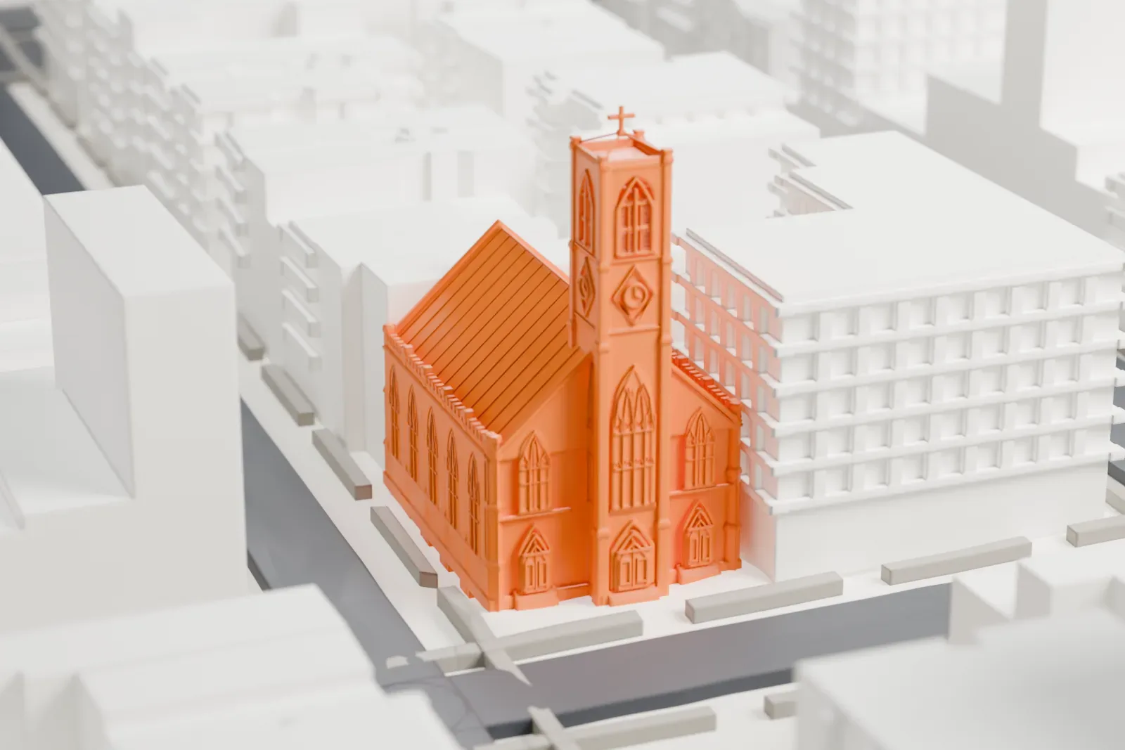 A white 3D print of St. Teresa Church, a gabled church with a tall square tower topped by a cross, standing between taller buildings.