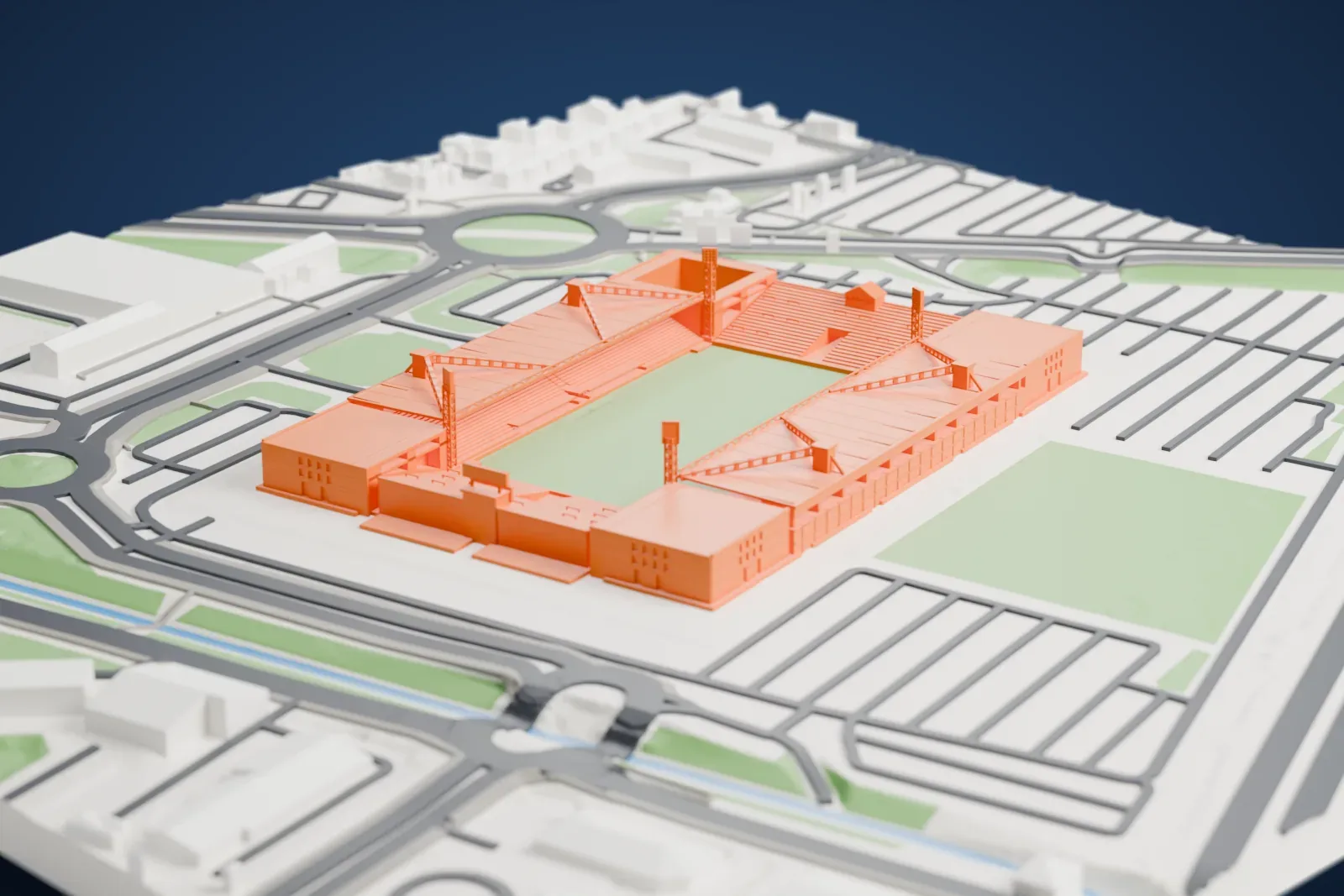 A white 3D print of the Stade des Costières, a rectangular football stadium with two roofed stands and a green pitch, surrounded by roads and parking areas.