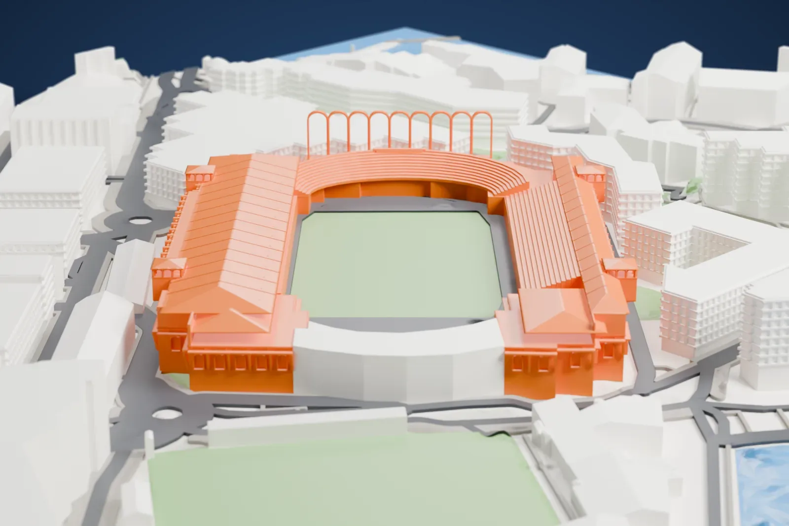 A white 3D print of the Stade Louis II, a stadium with long pitched roofs, projecting stair towers and a row of nine tall open arches, among surrounding streets and buildings.