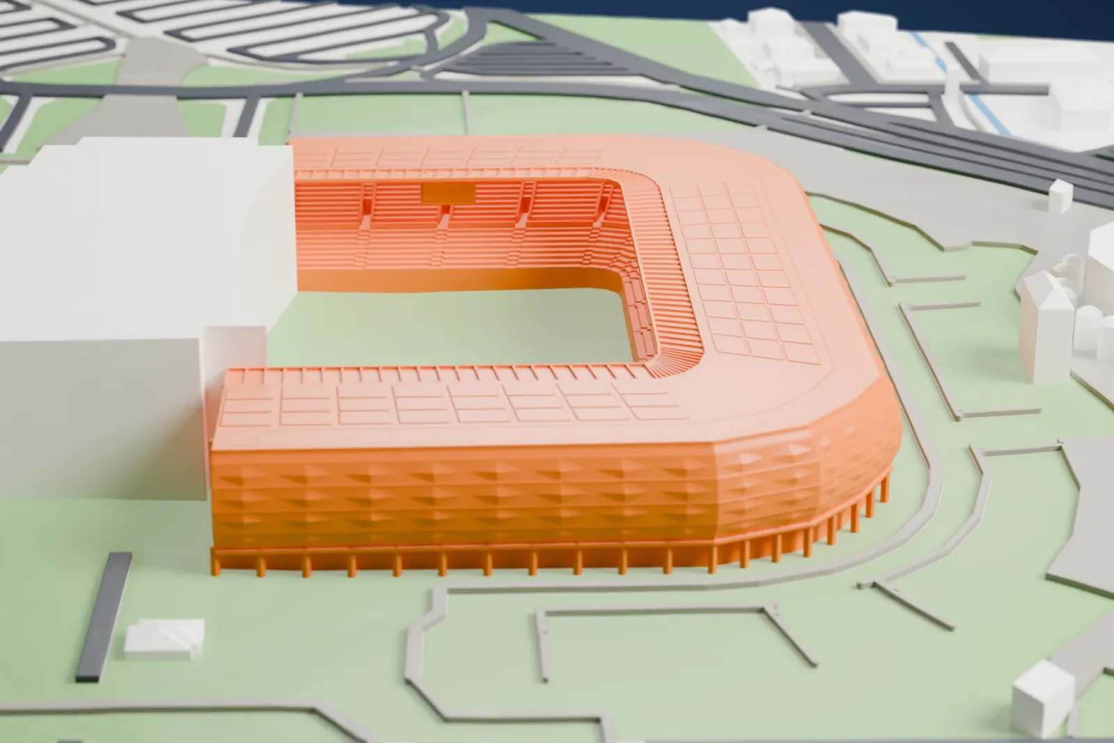 A white 3D print of the Stadio Friuli, a three-sided bowl with a low roof and two tiers of seats, among surrounding streets and buildings.
