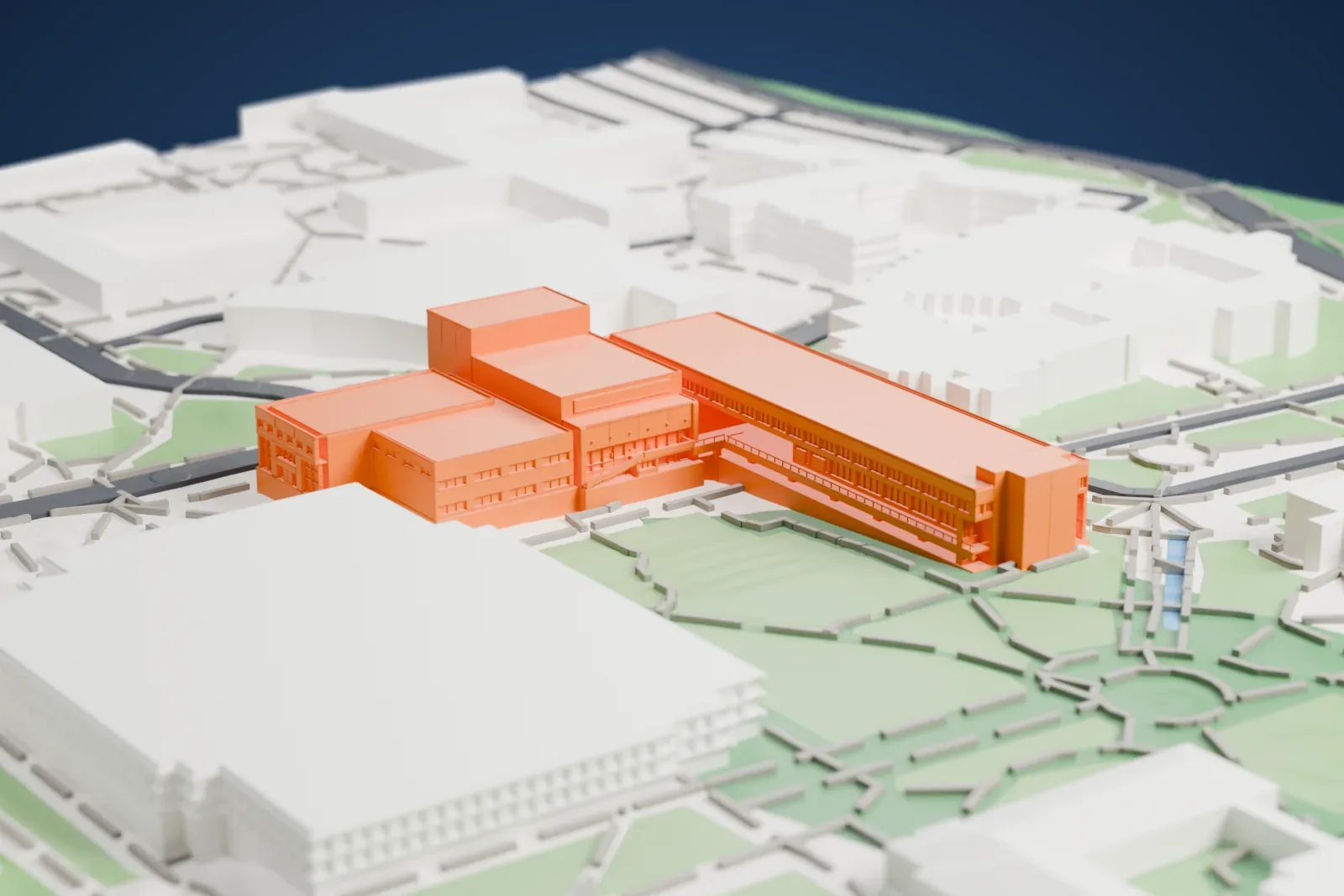 A white 3D print of the Staller Center for the Arts, a cluster of large blocky buildings with a long slab wing, beside campus lawns and winding paths.