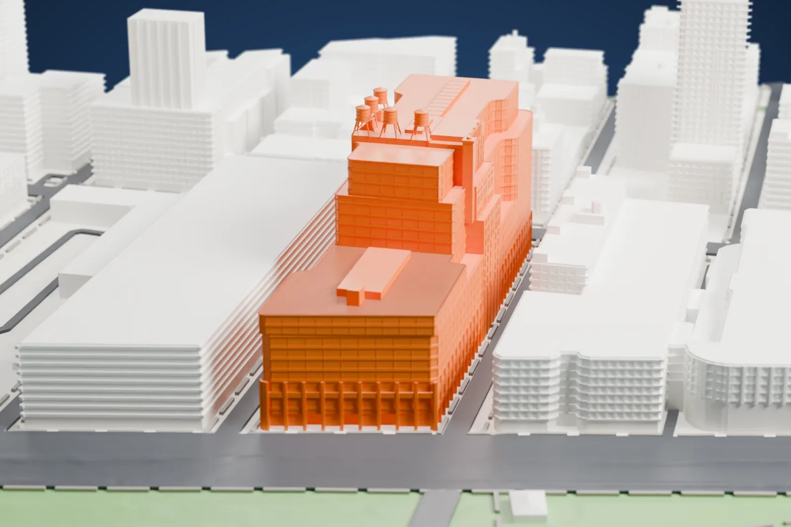 A white 3D print of the Starrett–Lehigh Building, a large stepped block with banded facades and small rooftop structures, beside streets and the waterfront.