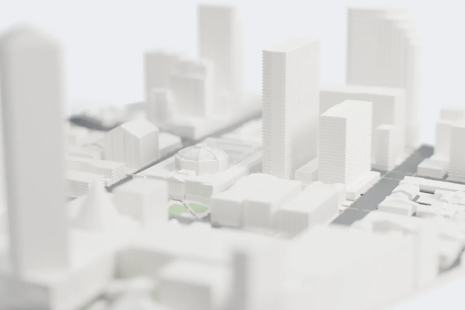 A white 3D print of State Library Victoria, a block-wide building with a large central dome and a columned front, standing among taller towers and city streets.