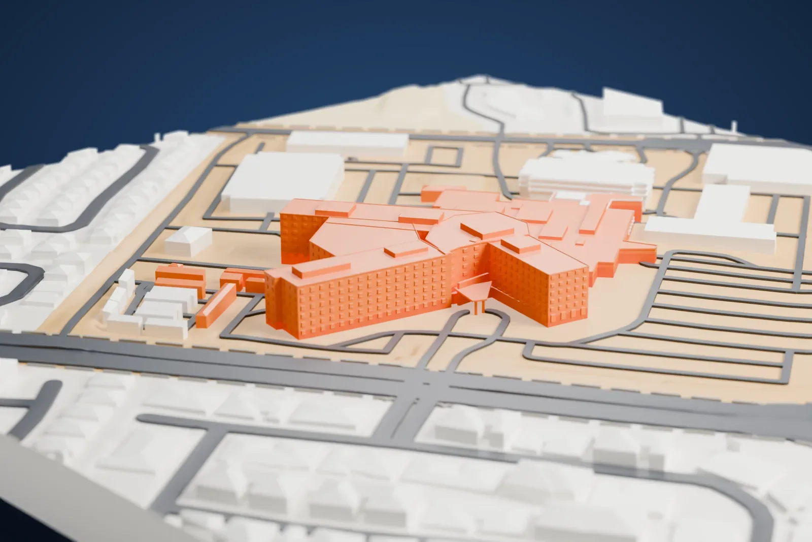 A white 3D print of Summerlin Hospital, a wide multi-wing hospital complex of several heights, surrounded by parking lots, roads and nearby houses.