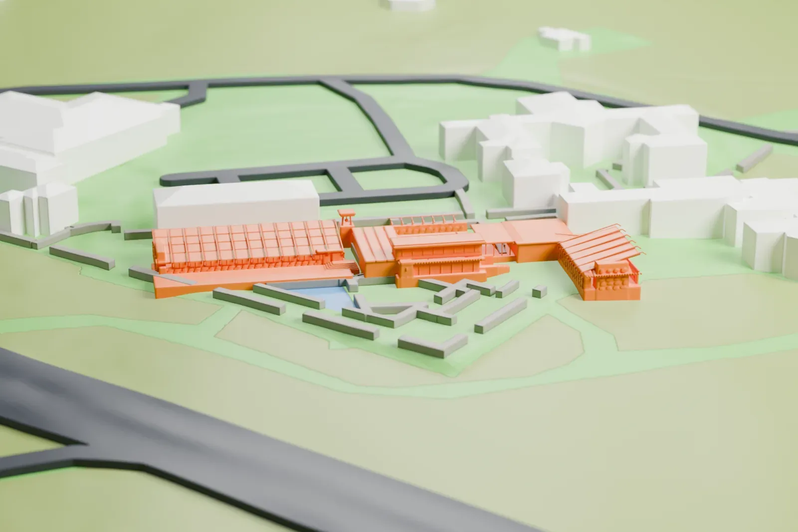 A white 3D print of Taliesin West, a low group of connected buildings with grid-patterned roofs beside a small pool, set in open ground with roads and larger buildings nearby.