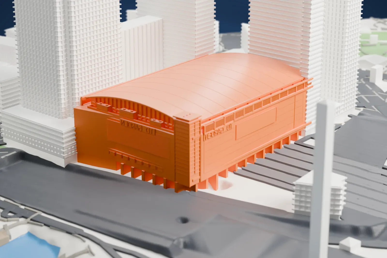 A white 3D print of TD Garden, a wide arena with a long arched roof, surrounded by tall towers, wide roadways and a stretch of water.