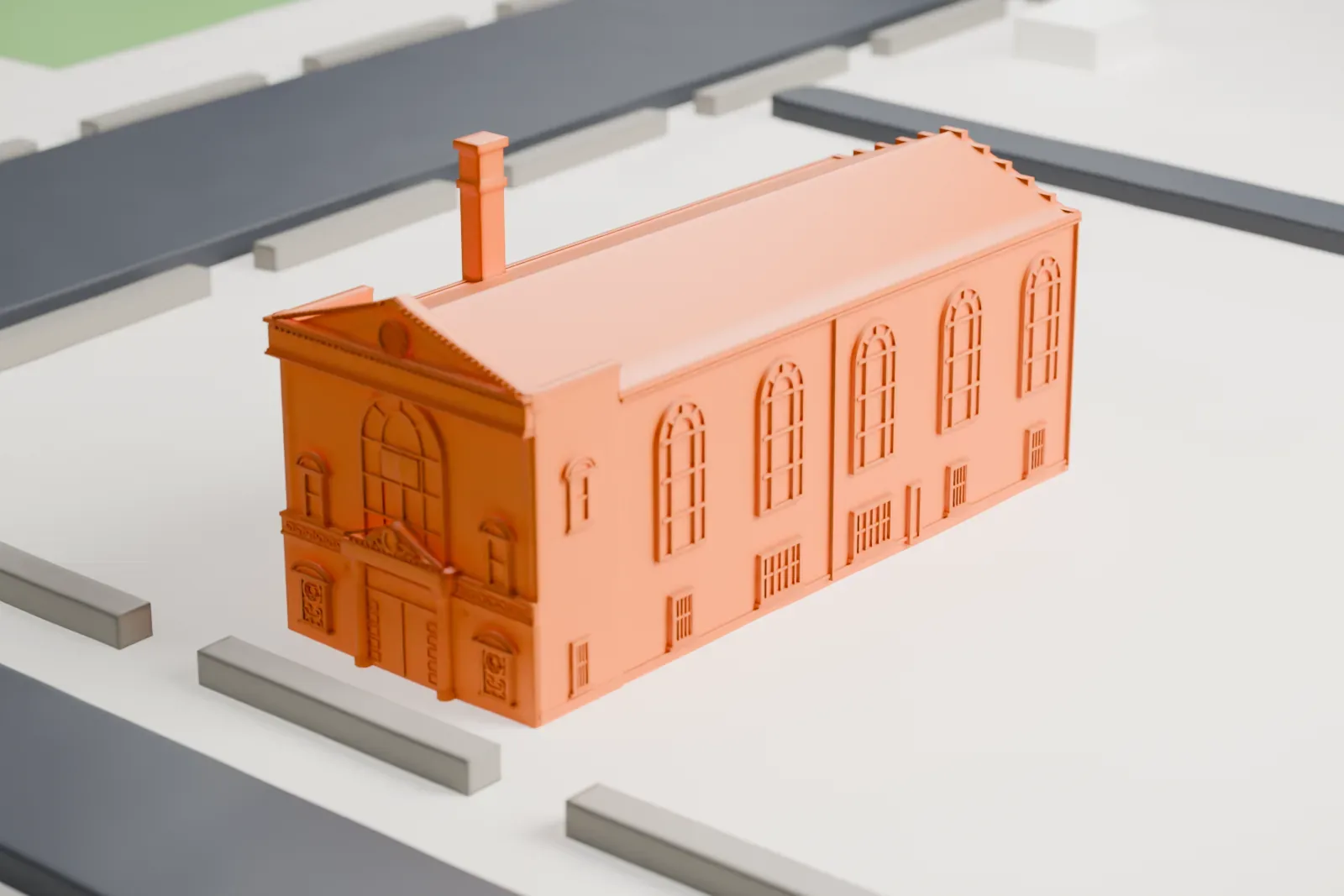 A white 3D print of the Temple of Israel Synagogue, a small gabled building among larger buildings, lawns and curving streets.