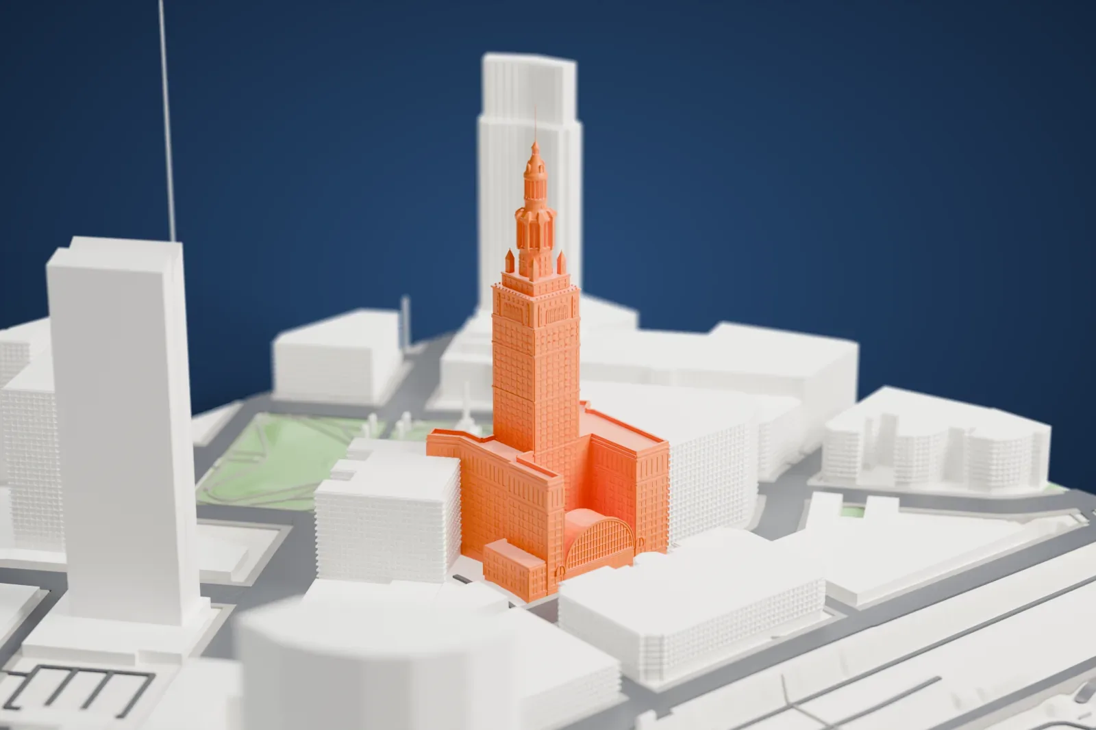 A white 3D print of the Terminal Tower, a tall stone skyscraper with a stepped crown and mast, standing on Public Square among surrounding buildings.