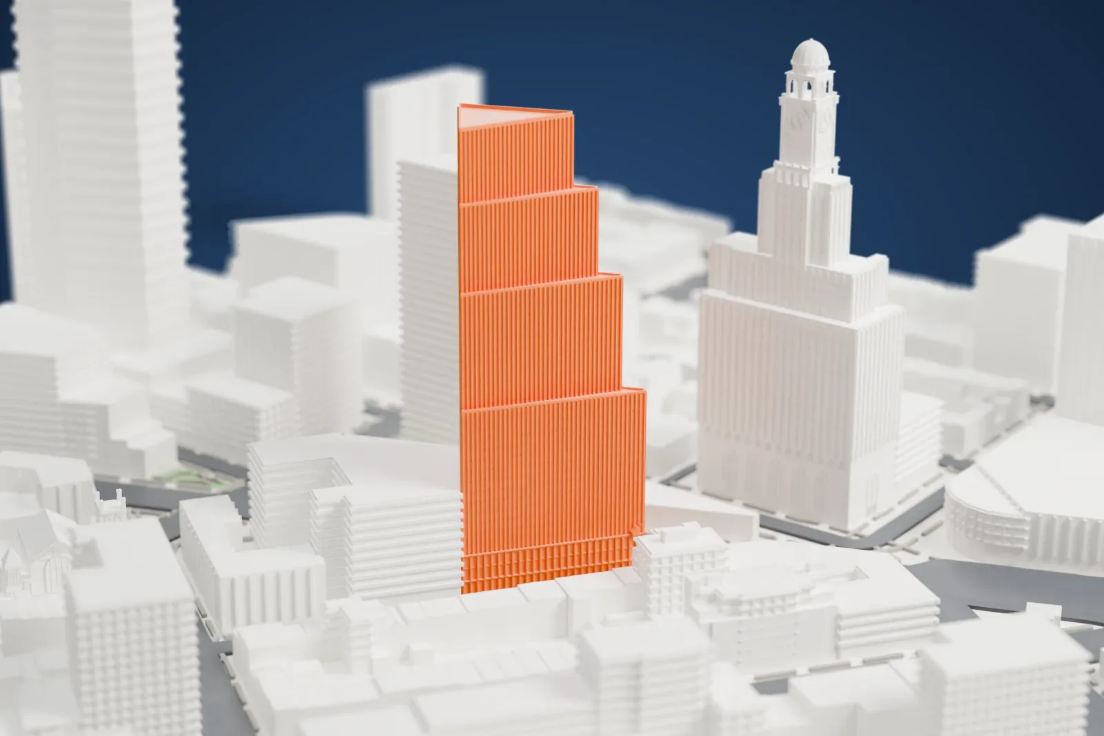 A white 3D print of The Alloy Block, a tall tower with stepped setbacks and a triangular top, rising above nearby buildings and streets.