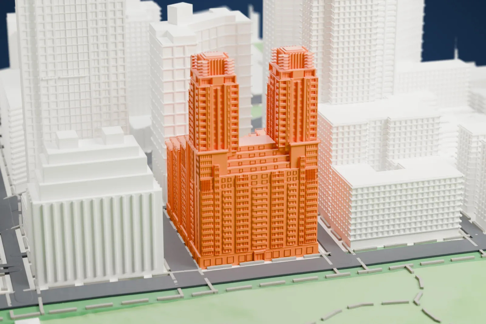 A white 3D print of The Century, a stepped building with twin towers rising from a wide base beside a green park, among taller buildings.