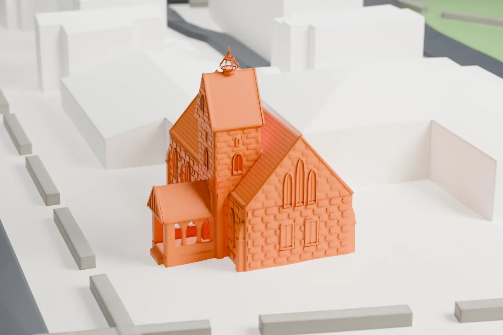 A white 3D print of The Church-in-the-Gardens, a gabled church with stone-textured walls, a tower and a small porch, standing on open ground with houses and a road nearby.