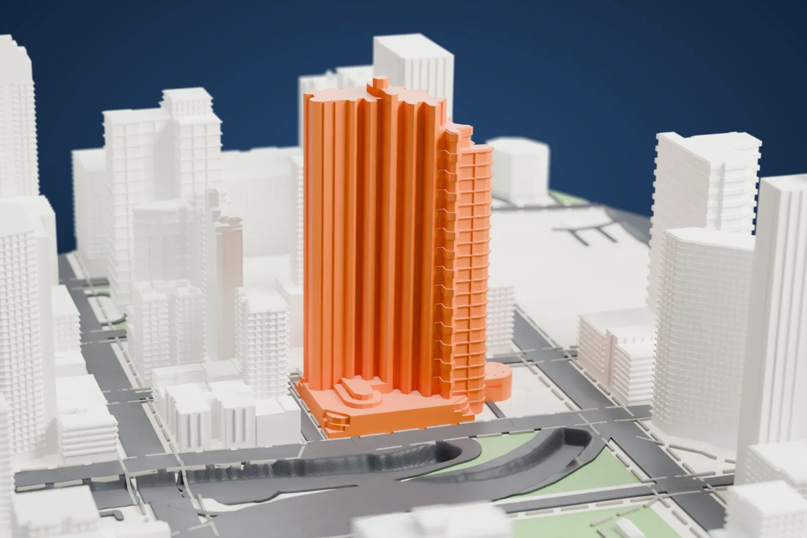 A white 3D print of The Corinthian, a tall tower of clustered fluted columns with a curved low base, beside a green plaza, roads and other buildings.