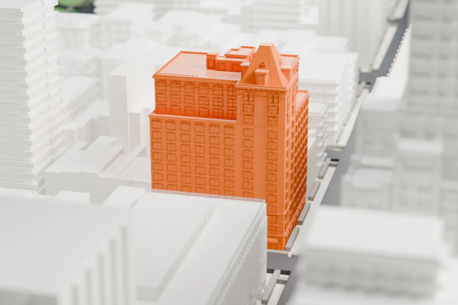 A white 3D print of The Mark Hotel, a tall building with a steep pitched roof tower, squeezed between taller buildings in a dense city block.