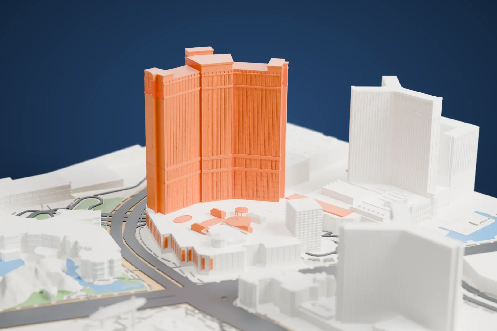 A white 3D print of The Palazzo, a tall curved tower with stepped tops rising from a low podium with round roof structures, among large neighboring buildings and wide roads.