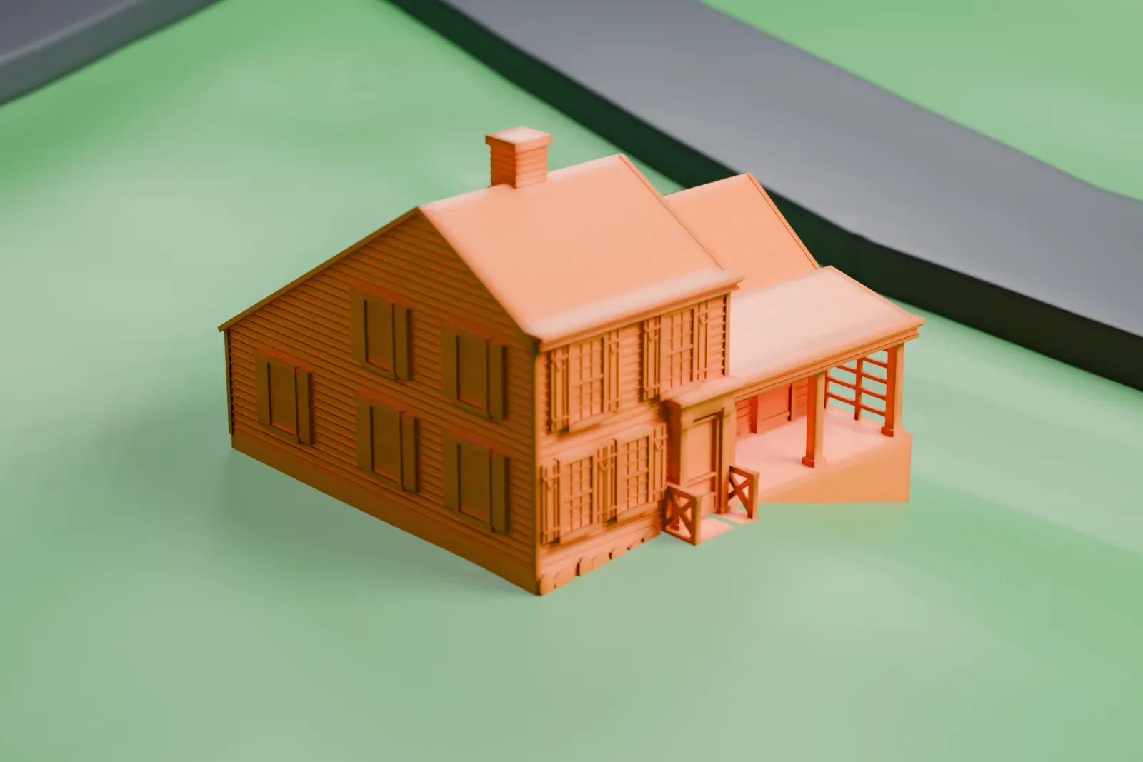 A white 3D print of the Thomas Paine Cottage, a small two-story house with a side wing and a chimney, on a green lawn beside a road.