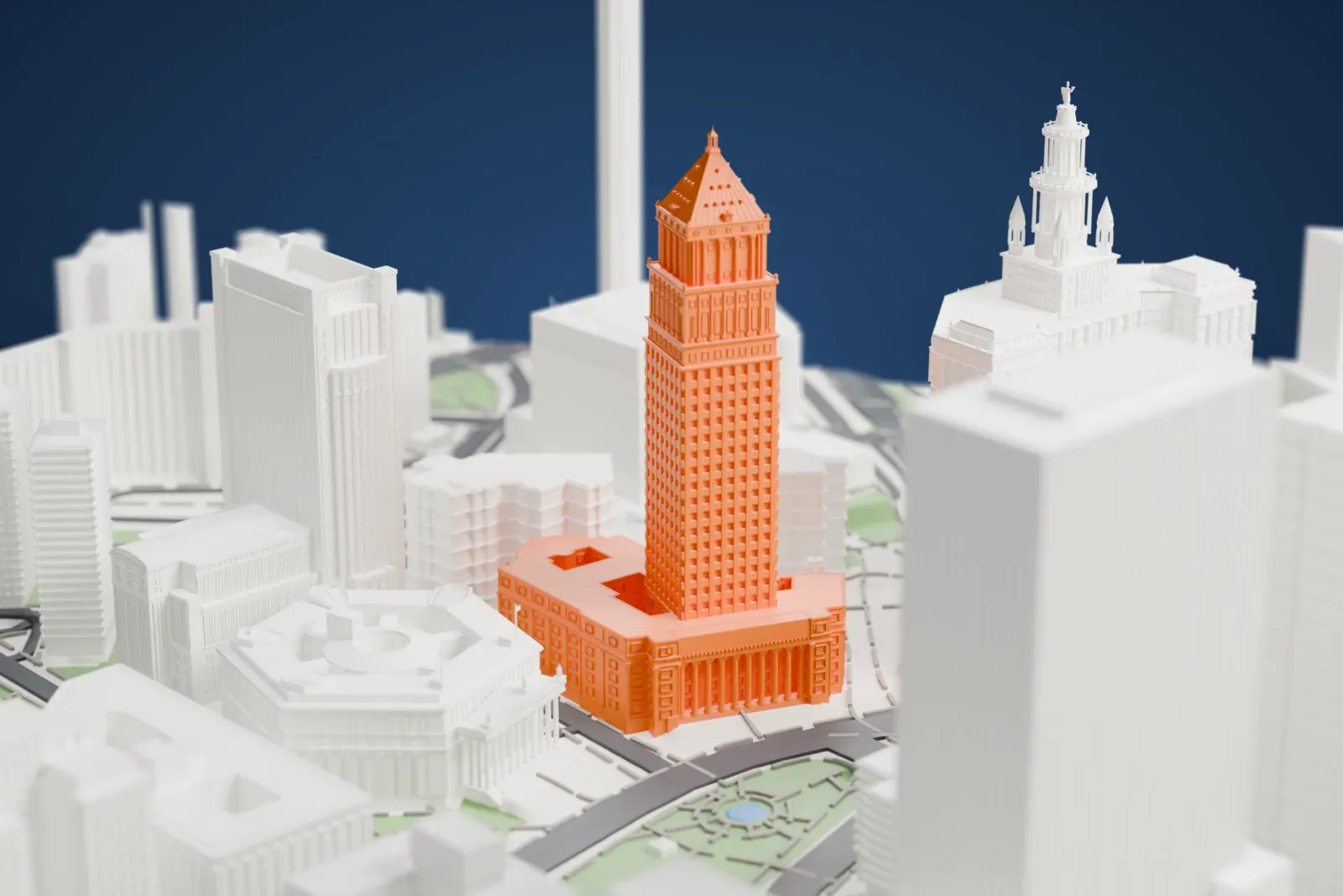 A white 3D print of the Thurgood Marshall United States Courthouse, a tall tower with a pyramidal roof on a wide base, among government buildings, roads and green spaces.