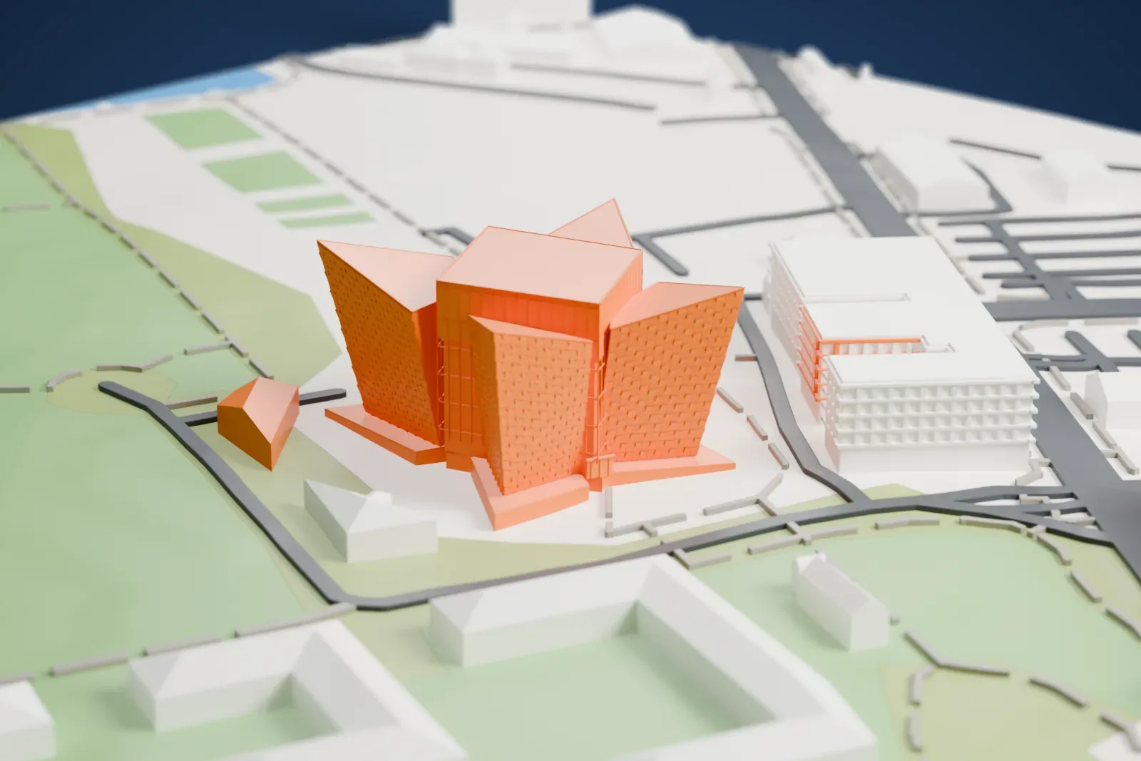 A white 3D print of Titanic Belfast, a star-shaped building of four sharply angled prows covered in small shards around a central block, standing on open ground with grass, paths and a few nearby buildings.