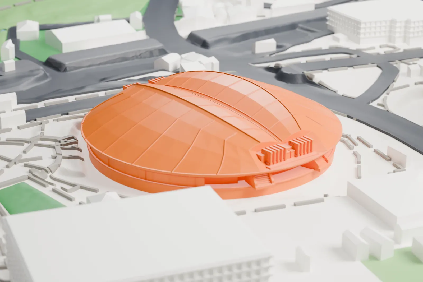 A white 3D print of the Tokyo Metropolitan Gymnasium, a wide, low arena with a ribbed, shell-like roof and a ridge across the top, set among roads, small buildings and patches of green.