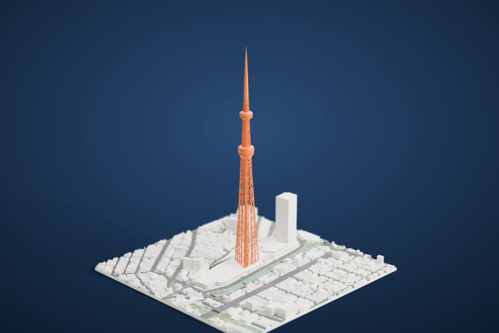 A white 3D print of Tokyo Skytree, a very tall lattice tower with two round observation decks and a needle-thin spire, rising from dense city blocks beside a canal.