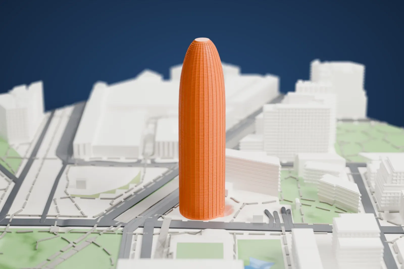 A white 3D print of Torre Glòries, a bullet-shaped tower with a domed top, standing among mid-rise blocks, roads, green squares and a patch of water.