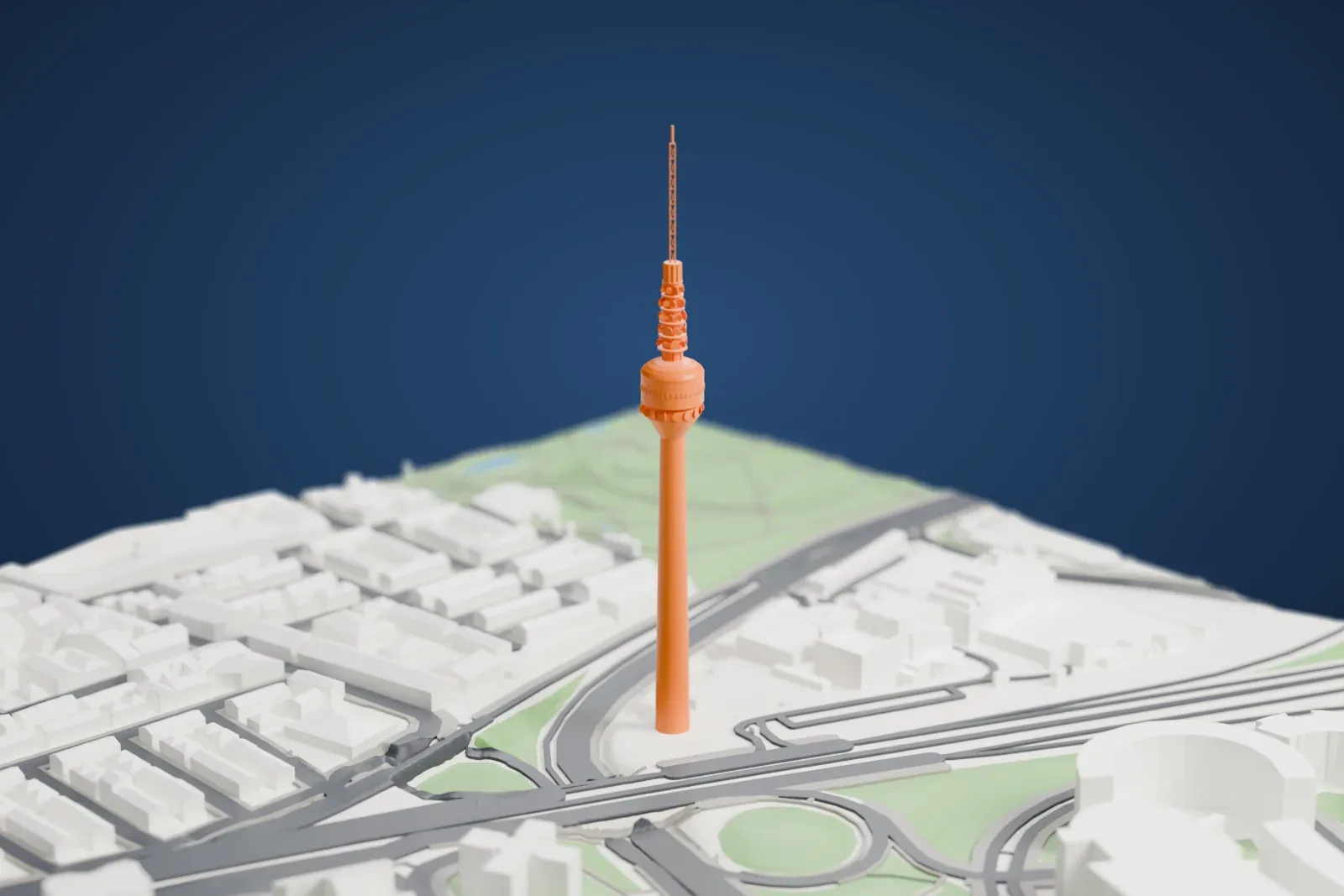 A white 3D print of Torrespaña, a tall concrete tower with an antenna, standing among the surrounding city buildings.
