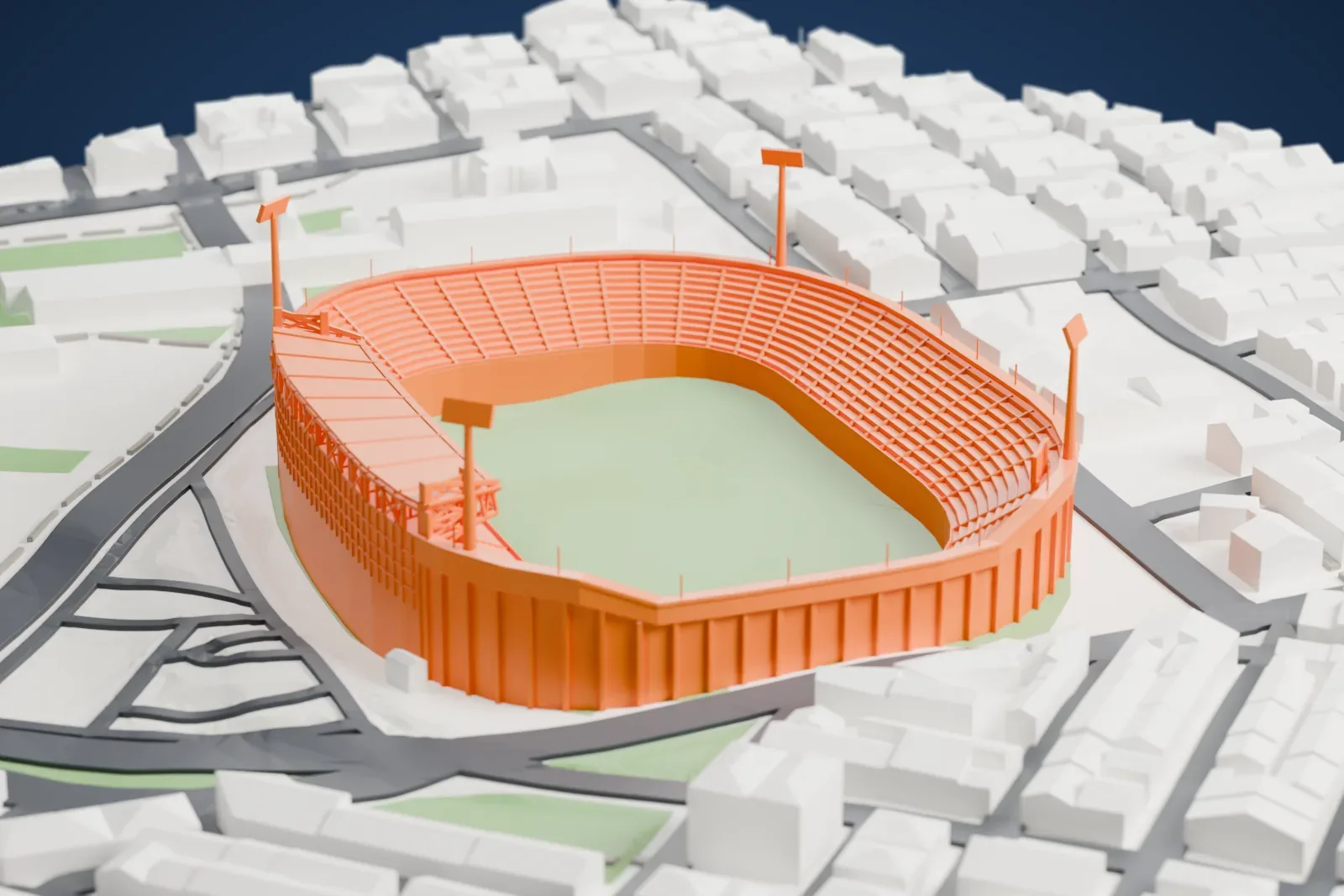 A white 3D print of Toumba Stadium, a single-tier oval bowl around an open pitch with a steel-roofed main stand on one side and four floodlight masts at the corners, among the surrounding streets and buildings.