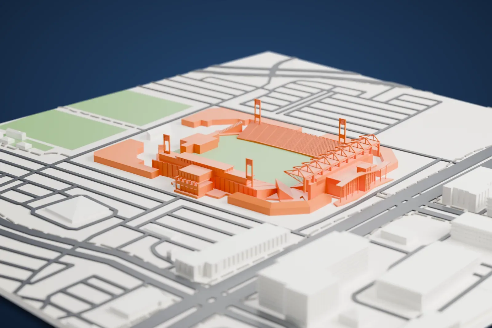 A white 3D print of Toyota Stadium, a U-shaped soccer stadium with raked seating, a truss-framed roof over one end and four slim towers, surrounded by streets, open ground and a few low buildings.