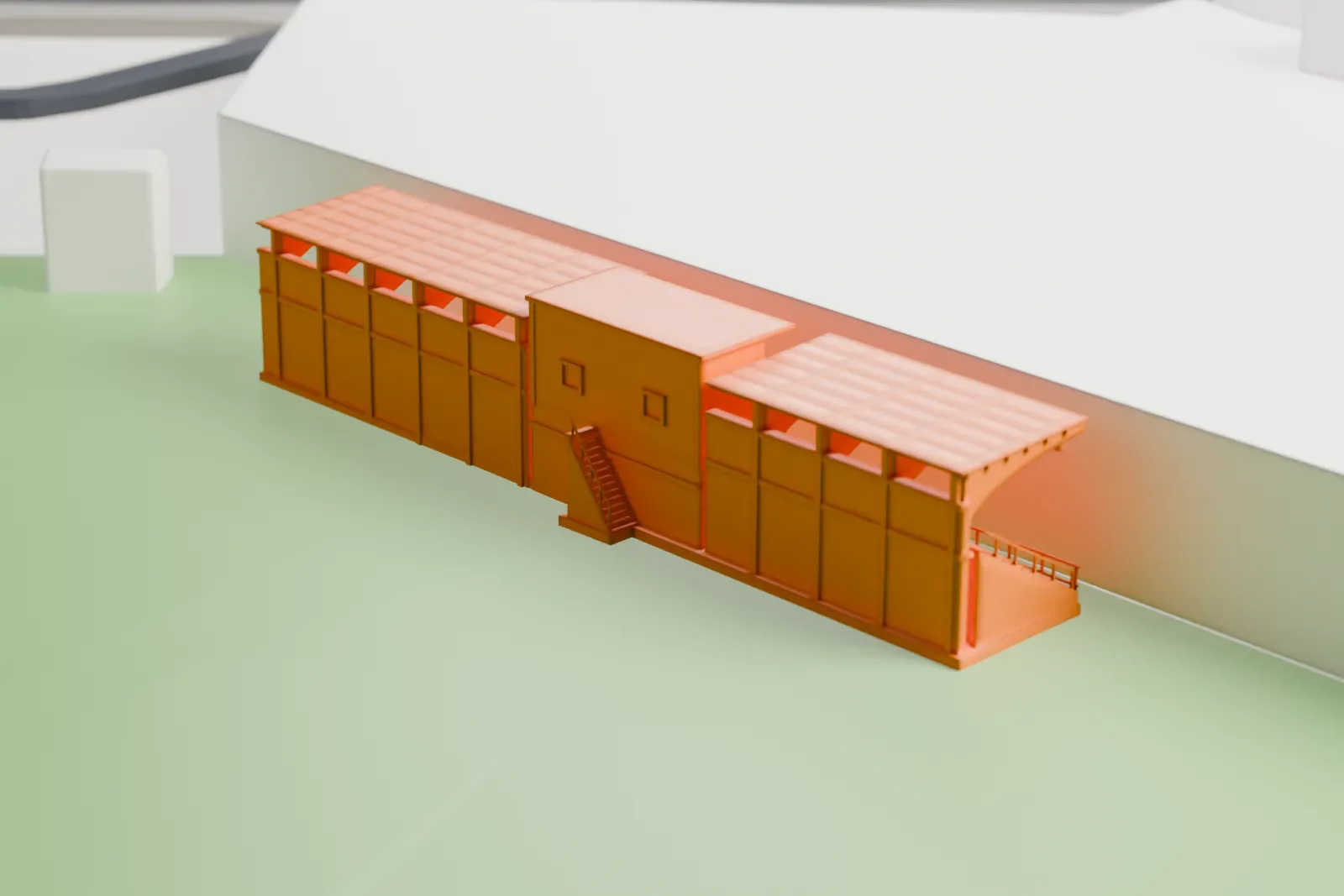 A white 3D print of a covered stand at the Trinidad Stadium, with flat roofs stepping up over a raised pavilion, standing on open green ground.