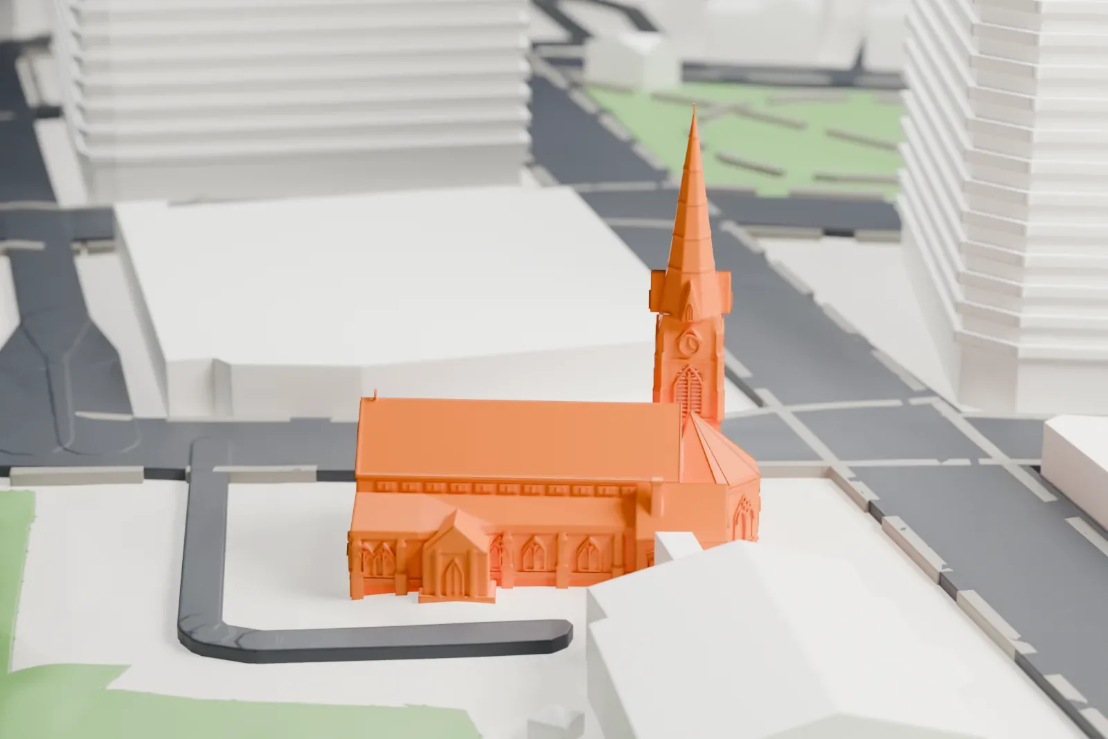 A white 3D print of Trinity-St. Paul's Episcopal Church, a long church with a tall corner tower and spire, on a paved lot beside lawns and roads.