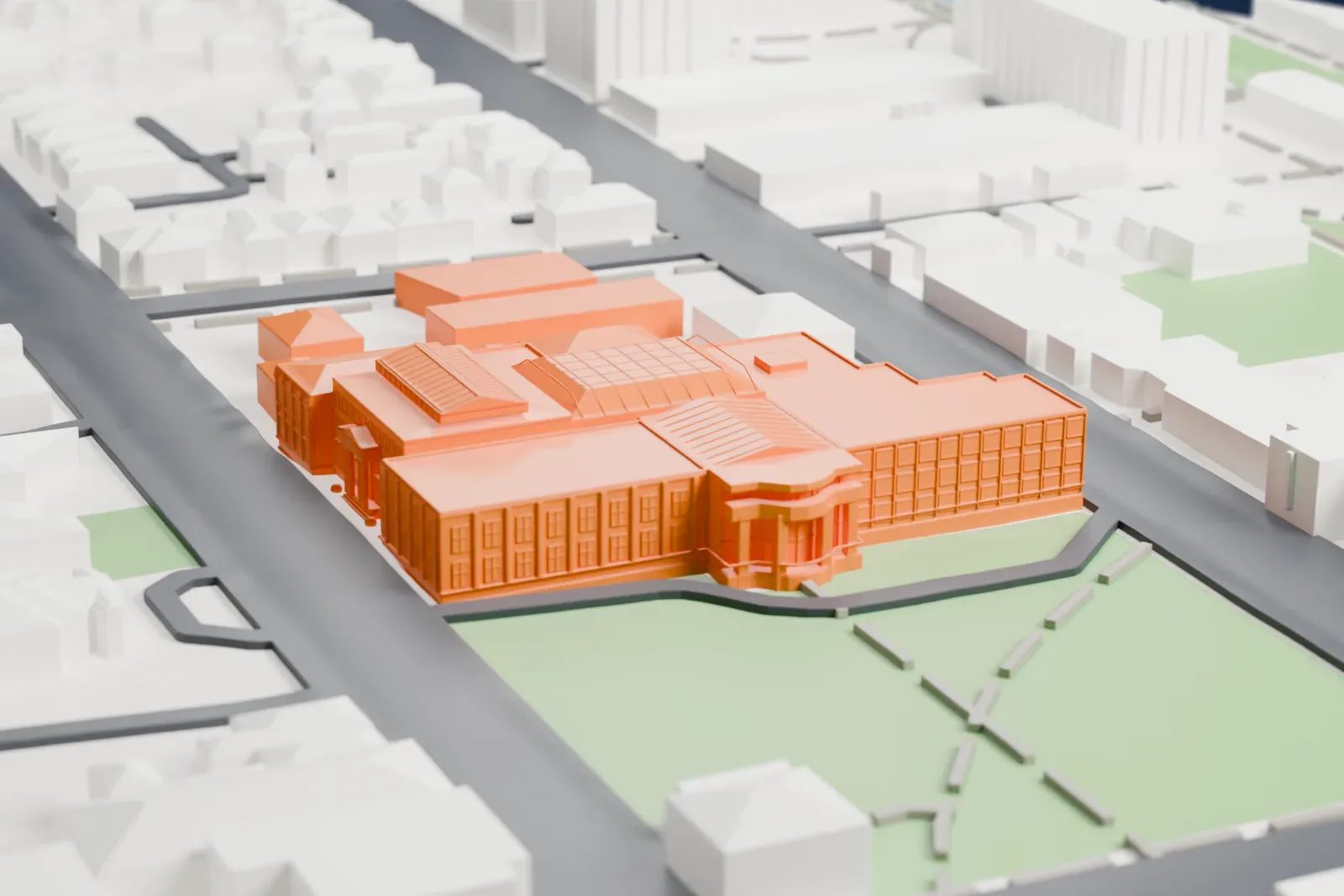 A white 3D print of Tūhura Otago Museum, a multi-wing building with hipped roofs, glazed skylight ridges and a small columned portico, beside lawns and low houses.