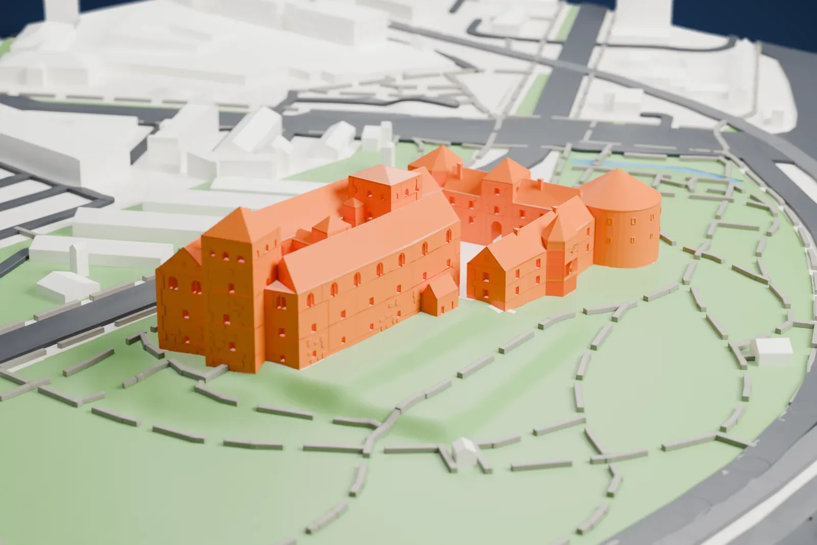 A white 3D print of Turku Castle, a cluster of steep-roofed blocks with corner towers and a round tower with a conical roof, set in a park with winding paths, roads and water beyond.