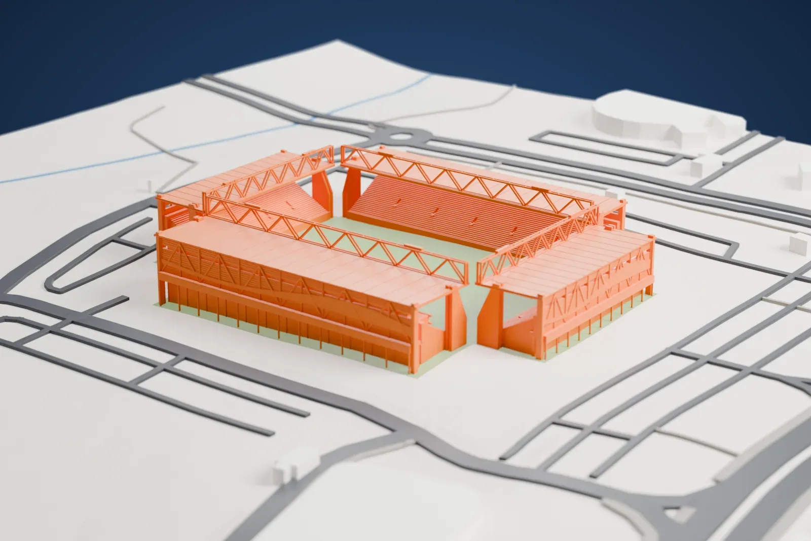A white 3D print of Turner Stadium, with four separate roofed stands around an open pitch and the surrounding buildings of Be'er Sheva.